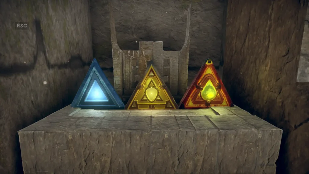 Three glowing triangular Artefact Stones (blue, yellow, red) resting on a stone pedestal within Hunted In Maze, serving as keys for the main story.